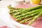 Fresh green asparagus in a plate on a beige background. Close-up