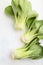 Fresh green bok choy or pac choi chinese cabbage on a white concrete background. Top view, close up