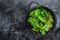 Fresh green chard mangold leaves in colander. Black background. Top view. Copy space