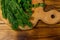 Fresh green dill and parsley on cutting board on wooden table