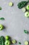 Fresh green fruits, kale and spinach on gray background with copy space, top view