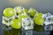 Fresh green grapes with water drops and ice cubes on gray background