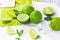 Fresh green juicy limes and lime slices with mint leaves in the kitchen on light background.