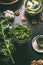 Fresh green kale pesto in glass with kale leaf on dark kitchen table background, top view