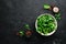 Fresh green lettuce salad in a plate on a wooden background Top view. Free space for your text.