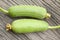 Fresh green Luffa cylindrica fruit on wooden table