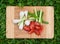 Fresh green onions and cherry tomatoes on the old wooden cutting board, closeup food, outdoors shot.