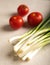 Fresh green onions on a gray stone background.