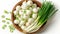 Fresh green onions in wooden bowl on white background, enhanced by natural lighting