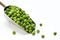 Fresh green peas in a metal scoop on a white background
