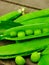 Fresh green peas on wood background.  peas, pods and leaves set. Healthy food. Macro shooting.