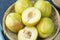 Fresh Green plum or Flavor Grenade Pluot closeup, Green plum in Bamboo basket on wooden table in garden.