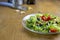 Fresh green Salad recipe ingredient black olives garlic fork on wooden table