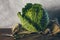 A fresh green savoy cabbage on the sackcloth on the wooden table