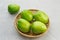 Fresh green tomatoes on bamboo plate.