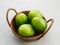 Fresh green tomatoes on rattan basket.