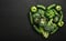 Fresh green vegetables arranged in heart shape on a black stone table