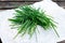 Fresh Green Vegetables Bunch of Chives on crumpled paper and old wooden table.