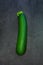 Fresh green zucchini isolated on dark slate stone backgroun