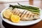 fresh grilled fish plated with a side of asparagus and lemon