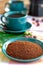 Fresh ground arabica coffee and cup with black coffee served outside with raw green, mature red and roasted coffee beans,
