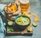 Fresh guacamole sauce in blue ceramic bowl, corn chips, beer