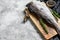 Fresh haddock fish carcass on the cutting Board. Gray background. Top view. Copy space