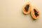 Fresh halved papaya fruit on beige background, flat lay. Space for text