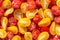 Fresh halves of Brazilian cherry tomatoes. Background of many colorful cherry tomatoes. Sliced yellow and red cherry tomatoes.