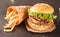 Fresh hamburger with french fries on black stone