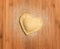 Fresh,handmade,single raviolo in the shape of heart,covered with flour and placed on the wooden table and covered with flour.