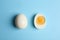 Fresh hard boiled chicken eggs on blue background, flat lay