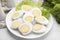 Fresh hard boiled eggs and lettuce on white tiled table