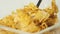 Fresh healthy food. Spoon grabs yellow cornflakes with white milk from transparent bowl on a white background