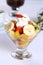 Fresh healthy fruit salad in a glass with whipping cream
