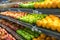 Fresh healthy fruits on shelves in supermarket. With a woman hand choosing best fruits