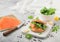 Fresh healthy organic sandwich with bagel and salmon, cream cheese and wild rocket on chopping board with smoked salmon pack