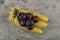 Fresh healthy plums with banana cluster on stone background