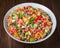 Fresh healthy salad with quinoa, colorful tomatoes, sweet pepper, cucumber and parsley on wooden background close up.