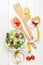 Fresh healthy salad, utensils and tape measure over white wooden