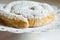 Fresh home baked traditional Spanish and Philippine coiled sweet bread ensaimada sprinkled with icing sugar on cake stand