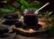 Fresh homemade blackberry jam in glass jar on a wooden background. Several fresh berries are near it.