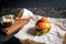 Fresh homemade burger on little cutting board with grilled potatoes, served with ketchup sauce and sea salt over wooden table with