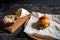 Fresh homemade burger on little cutting board with grilled potatoes, served with ketchup sauce and sea salt over wooden table with