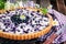 Fresh homemade creamy blueberry tart open pie on rustic backgr