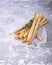 Fresh homemade crispy bread sticks with thyme and sea salt on a gray concrete background herbs