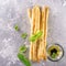 Fresh homemade crispy bread sticks with thyme and sea salt on a gray concrete background herbs