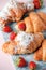 Fresh homemade croissants with strawberry and various toppings. Top view. French bakery concept