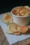 Fresh homemade deep fried crispy potato chips in white box on a wooden background, top view. Salty crisps scattered on a table for