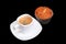 Fresh homemade muffin, cake and white cup of Cappuccino on dark background.